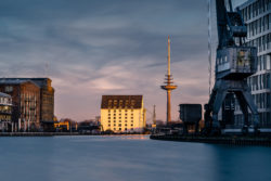 Abendlicht im Stadthafen Münster mit Getreidespeicher und Fernmeldeturm, stille Reflexion im Wasser.