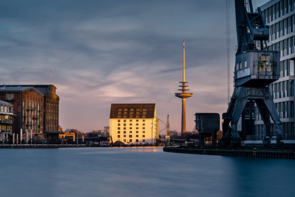 Abendlicht im Stadthafen Münster mit Getreidespeicher und Fernmeldeturm, stille Reflexion im Wasser.