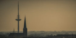 Silhouette der Herz-Jesu-Kirche und des Fernsehturms in Münster bei Dämmerung, festgehalten von Jonas Hofmann.