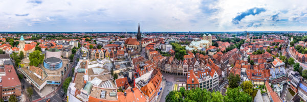 Panoramaansicht von Münster mit markanten Sehenswürdigkeiten wie St. Lamberti, Liebfrauen-Überwasserkirche und dem Prinzipalmarkt.