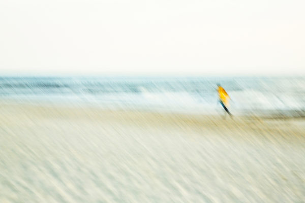 Abstrakte Darstellung eines Strandlaufs mit Bewegungsunschärfe in Blau- und Beigetönen, künstlerisch festgehalten von Annemarie Berlin.