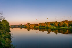 Ein ruhiger Aasee spiegelt die farbenfrohen Heißluftballons der Warsteiner Internationale Montgolfiade wider. Die herbstlichen Bäume und der blaue Himmel vervollständigen das idyllische Bild. Das Foto wurde von Sascha Talke aufgenommen und ist Teil unserer Bilddatenbank_2020.