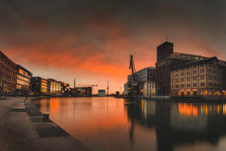 Foto des Münsteraner Stadthafens bei Sonnenuntergang mit Hafenkran und Theater im Hintergrund