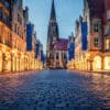 Hochformat Foto des Prinzipalmarkts in Münster, mit historischen Gebäuden, Europafahnen und der Lambertikirche im Hintergrund.